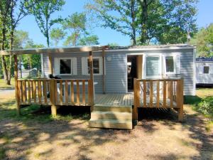 ein kleines Haus mit einer Veranda und einer Terrasse in der Unterkunft Mobil-home 6 pers Coeur de Vendée in Le Pont Legé