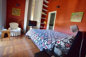 - une chambre aux murs orange avec un lit et une chaise dans l'établissement 2 camere con pianoforte, à Naples