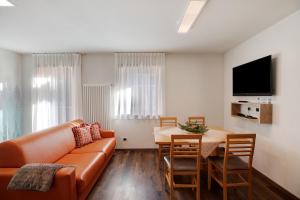 a living room with a couch and a table at Foresto Holiday Apartments Superior in Tesero