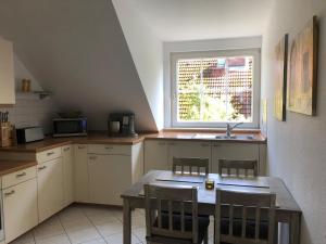 eine Küche mit einem Tisch und Stühlen sowie einem Fenster in der Unterkunft Charmante 2-Zimmer Wohnung in Hoisdorf
