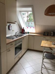 une cuisine avec évier et cuisinière ainsi qu'une fenêtre dans l'établissement Gemütliche 1 12-Zimmer Wohnung, à Hoisdorf