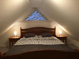 ein Schlafzimmer mit einem Bett mit zwei Lampen und einem Fenster in der Unterkunft Gemütliche 1 12-Zimmer Wohnung in Hoisdorf