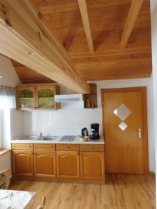 cocina con armarios de madera y puerta de madera en Haus Eugen, en Presseck