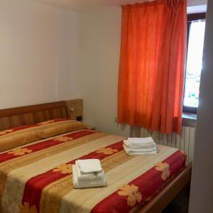 a bedroom with two beds with towels and a window at Appartamento Silvia in Vermiglio