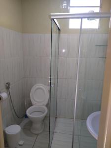 a bathroom with a toilet and a sink at Canto Sul Suítes in Ubatuba