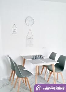 a table and chairs in a room with a clock on the wall at Ferienwohnung Zum Alten Radlereck in Lauchhammer