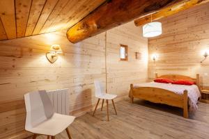 a bedroom with a bed and a wooden wall at La Réchasse in Termignon