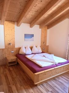 ein großes Bett in einem Zimmer mit Holzdecke in der Unterkunft Pferdehof Ansteingut in Schluderns