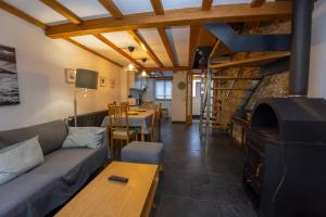 a living room with a couch and a fireplace at Casa Jovellanos de Casas Das Figueiras en Ría Eo-Ribadeo in Castropol