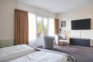 ein Hotelzimmer mit einem Bett und einem TV in der Unterkunft Montra Hotel Hanstholm in Hanstholm