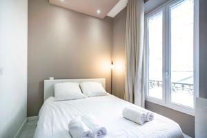 a bedroom with a bed with white sheets and a window at Frontière Monaco - Appartement moderne rénové - AH in Beausoleil