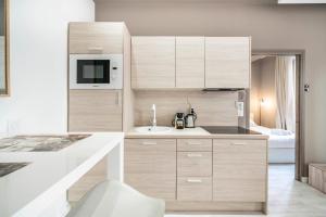 a kitchen with wooden cabinets and a sink at Frontière Monaco - Appartement moderne rénové - AH in Beausoleil