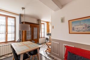 uma sala de estar com uma mesa e uma cozinha em La Bourguignonne 