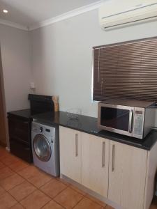 een keuken met een magnetron en een aanrecht bij Mimosa Self-Catering Studio Durbanville in Durbanville