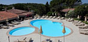 a large swimming pool with lounge chairs and umbrellas at Hotel Nibaru in Porto Cervo