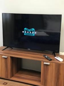 a television on a wooden stand with a remote control at Мини Отель «Positive” in Kyiv