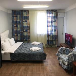 a bedroom with a bed and a chair and a window at Мини Отель «Positive” in Kyiv