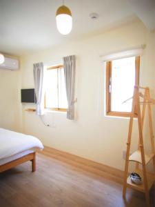 una camera da letto con un letto e due finestre di Mulight B&B a Nangan Altre 37 foto
