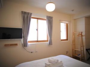 una camera da letto con un letto, una tv e una finestra di Mulight B&B a Nangan