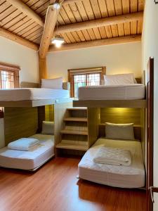 3 letti a castello in una camera con pavimenti in legno. di Mulight B&B a Nangan