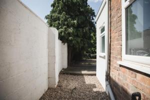 an alley with a door and a tree next to a building at Riverside park house in Leicester