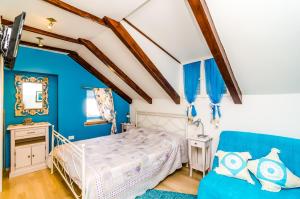 Holiday Home Tezoro Royal في دوبروفنيك: غرفة نوم زرقاء مع سرير وأريكة زرقاء +37 صورة