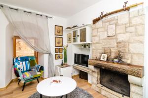 Holiday Home Tezoro Royal في دوبروفنيك: غرفة معيشة مع موقد حجري كبير