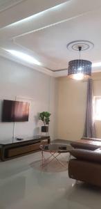 a living room with a couch and a flat screen tv at Your home II in Yaoundé
