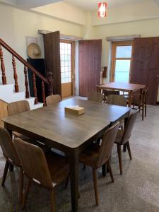 una sala da pranzo con un grande tavolo e sedie in legno di Mulight B&B a Nangan