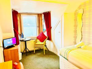 a bedroom with a bed and a chair and a window at Rowantreebank Bed and Breakfast in Arrochar