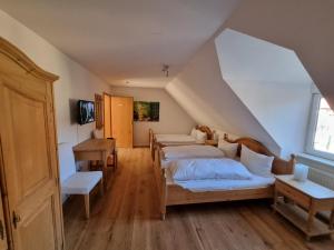 a attic room with two beds and a desk at Hotel & Restaurant Tanne in Fischingen