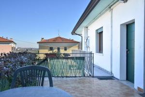 einen Tisch und einen Stuhl auf dem Balkon eines Hauses in der Unterkunft By the Hills Apartment in Montegrotto Terme