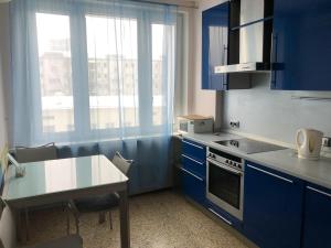 a kitchen with blue cabinets and a table and a window at Nice Flats Noviy Arbat in Moscow