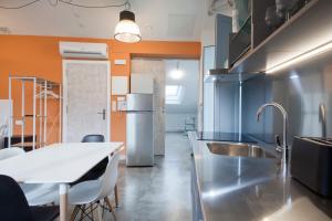 a kitchen with a sink and a table with chairs at Apartamentos Turísticos As Burgas 6 by Bossh Hotels in Ourense