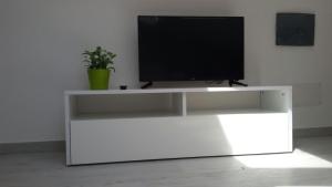 un centro de entretenimiento blanco con TV de pantalla plana. en Casa Lorenzo&Luca en Gonnesa