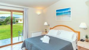 a bedroom with a bed and a sliding glass door at Hotel Nibaru in Porto Cervo