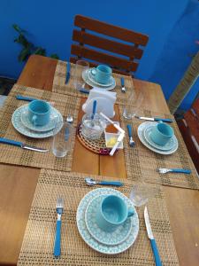 un tavolo in legno con tazze e piatti blu sopra di pousada corais de abrolhos a Caravelas