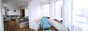 a living room with a blue chair and a bed at Pionier in Starý Smokovec +23 photos