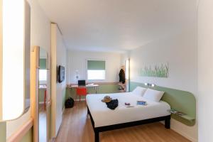 a room with a white bed and a desk at Ibis Budget Valencia Aeropuerto in Manises