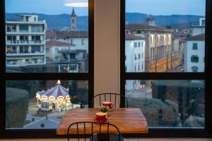a wooden table with two chairs and a view of a city at B&B 52cento in Arezzo