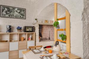 una pequeña cocina con mesa y chimenea en [ApuliaLux] Maison Pulli B&B vicino Bari, en Terlizzi