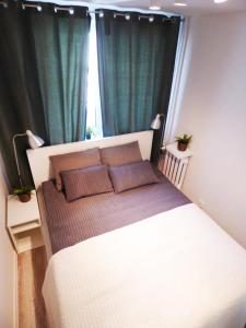 Schlafzimmer mit einem großen Bett und grünen Vorhängen in der Unterkunft Plac Grzybowski Apartment in Warschau