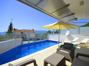 uma piscina com mobiliário de pátio e um guarda-sol em TOP-APARTMENT MONTENEGRO, with private Pool! em Kumbor