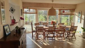 eine Küche mit einem Esstisch und Stühlen in der Unterkunft Grande maison avec SPA proche de CAEN et de la mer in Brouay