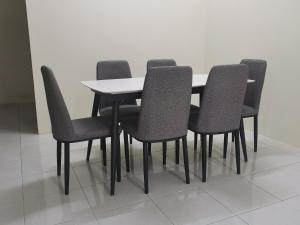 a dining room table with six chairs and a white wall at Padang Besar Homestay in Padang Besar