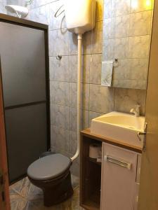 un baño con inodoro y lavabo en Silveira House, en Garopaba