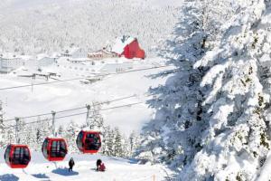 eine Gruppe von Menschen auf einem Skilift im Schnee in der Unterkunft ViP Apartments in Çekirge