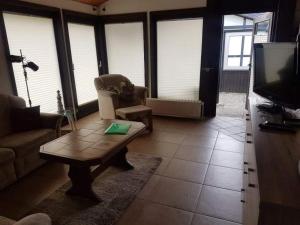 ein Wohnzimmer mit einem Sofa, einem Tisch und einem TV in der Unterkunft Bungalow M 43 in Burhave in Burhave