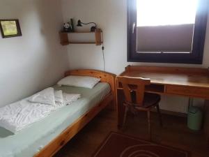 ein kleines Schlafzimmer mit einem Bett und einem Schreibtisch in der Unterkunft Bungalow M 43 in Burhave in Burhave