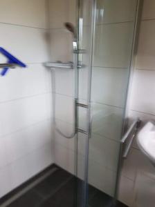 ein Bad mit einer Dusche und einem Waschbecken in der Unterkunft Bungalow M 43 in Burhave in Burhave